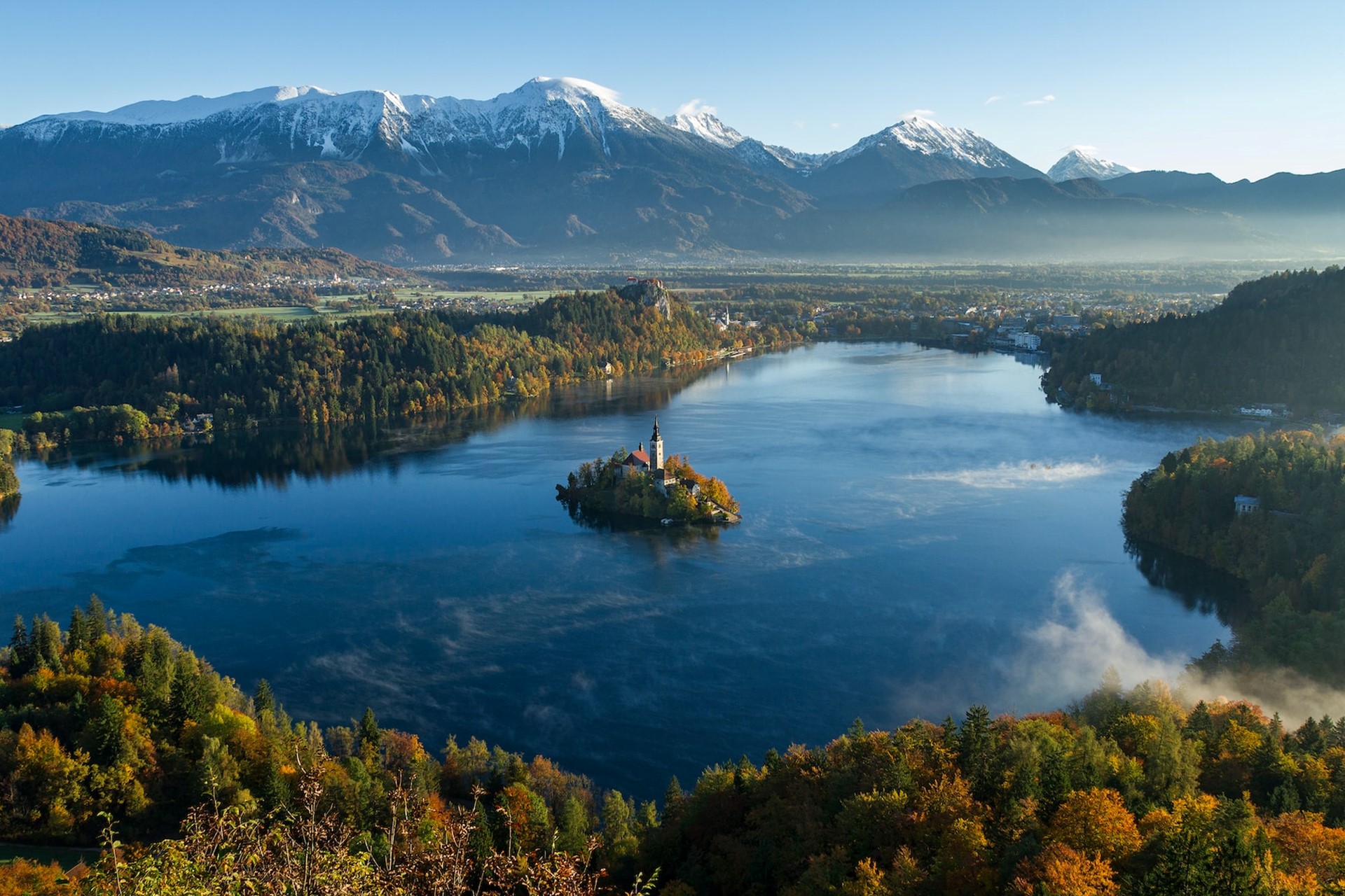 La petit île du Lac de Bled avec le paysage montagneux en arrière plan.